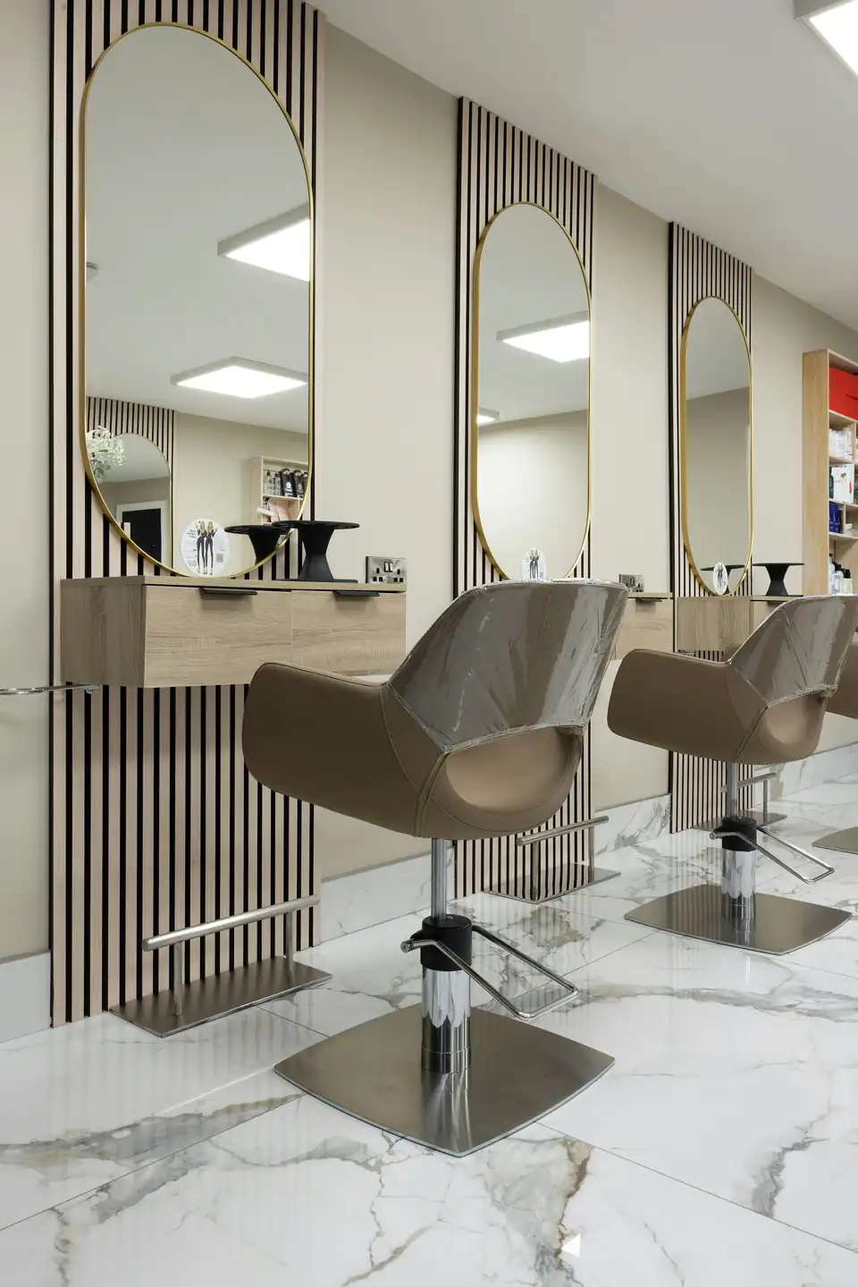 The styling stations: arched mirrors, slatted wood and white marble floors